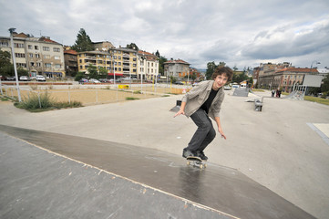 Boy practicing skate in a skate park - isolated