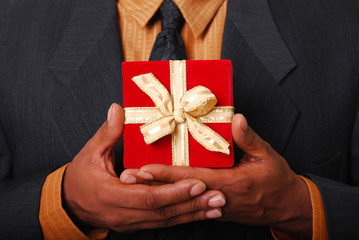 African-American male hands holding a red velvet box.
