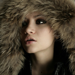 Fashion portrait of young pretty woman with fur
