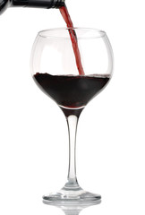 Red wine being poured from bottle into wineglass