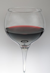 Glass of red wine against grey gradient background