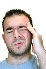 Obraz premium A young man grasps his head in anguish from pain