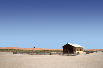 remote church in namib desert with  red dunes in background