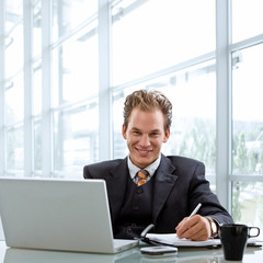 Fototapeta premium Happy smiling businessman working on laptop computer