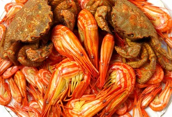 The Boiled prawns and crabs on plate.  White background.