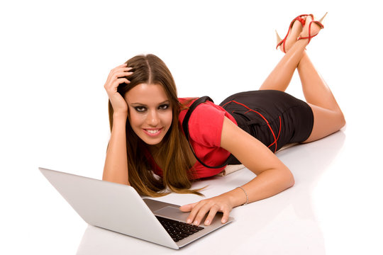 Full body of attractive woman lying on floor and using laptop.