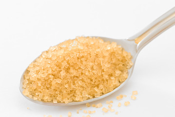 A spoonful of brown sugar on a white background