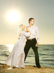 Young couple dancing on a beach at sunset