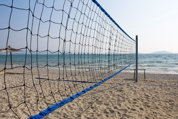 Beach volleyball net with sea in background