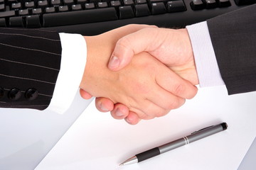 businessman's handshake over contract and pen