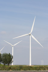 Fototapeta premium White wind turbine standing on open plain.