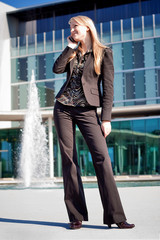 Obraz premium Business woman near office building talking on a phone