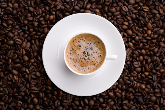 Kaffe in Tasse Untergrund aus Kaffeebohnen Vogelperspektive © unpict