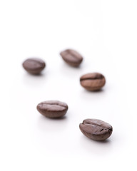 Fünf einzelne Kaffebohnen isoliert auf weiß