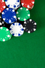 Stack of poker chips over green poker table
