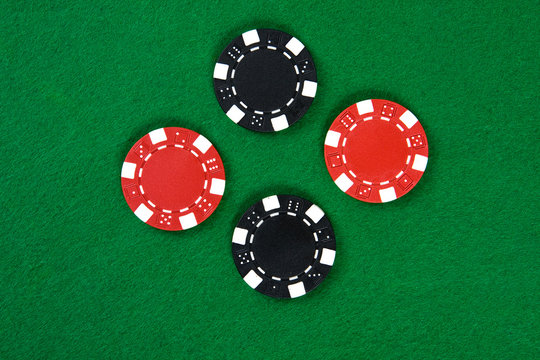 Two kinds of poker chips in the middle of green poker table