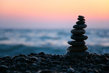 silhouette Small pyramid from stones on sunset seacoast