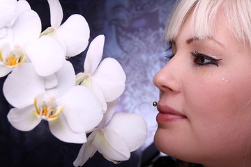 Beautiful young woman and white phalaenopsis orchid - obrazy, fototapety, plakaty