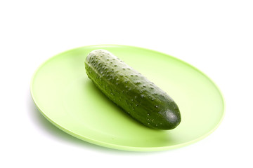 Ripe cucumber on a plate isolated on a white background