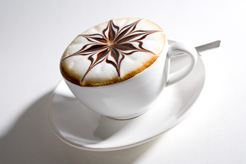 beautifully decorated cup of hot coffee with a star shape flower