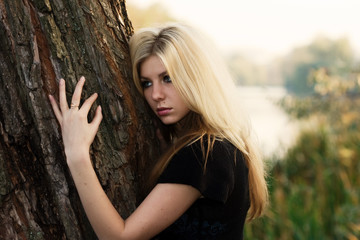 Beautiful young woman embracing a tree
