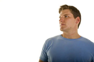 Fototapeta premium A young athletic looking man in a blue tshirt looking up