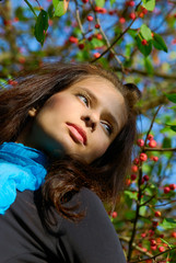Beautiful girl in the autumn red berries background.