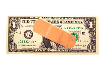 A band-aid on a US one dollar bill on white