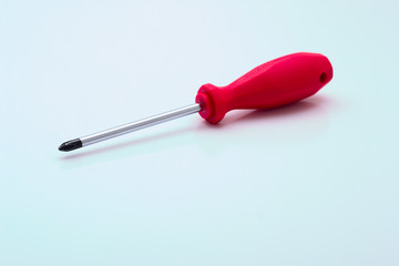Screwdriver with a red plastic pen on a white background