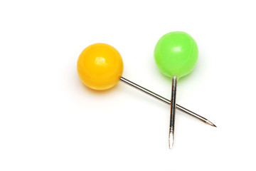 Yellow and green push pins isolated on white background.