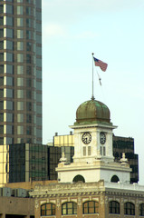 An old courthouse building with glass skyscraper behind