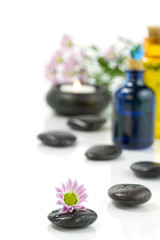 Fototapeta na wymiar Pebbles, candle, essential oils and flowers. Selective focus