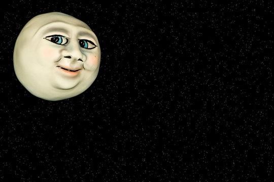 Oddly shaped moon with a face in front of a star field