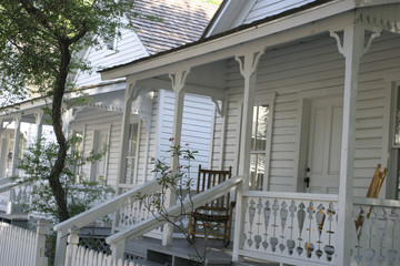 White row houses with porches, woodwork and a rocking chair