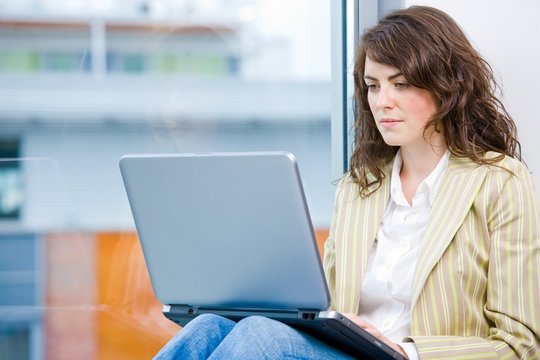 Young businesswoman sitting at office window,