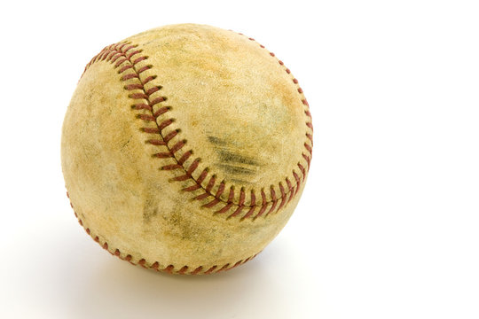Old, skuffed baseball  on a white field with a clipping path