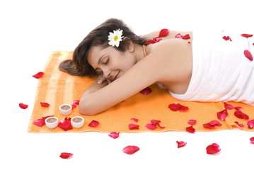 Naklejka na ściany i meble Beautiful Woman lying in the towel with petals .