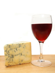 Glass of red wine and stilton cheese on a board