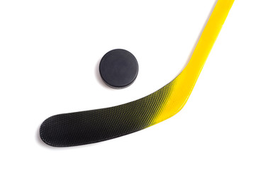 A yellow and black hockey stick and a puck
