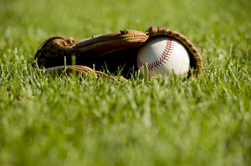 A white baseball in a brown leather baseball glove