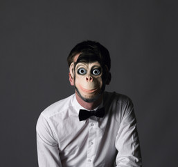 a man wearing a monkey mask in a white shirt and bow tie