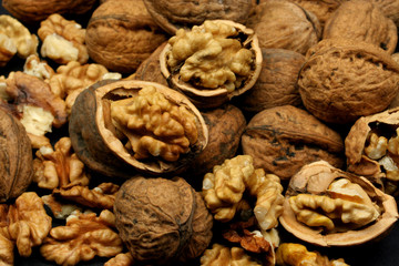 Cracked walnut shells and cores on black background
