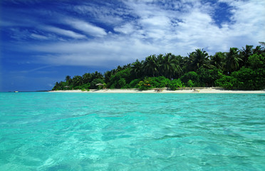 Tropical paradise with blue sea and green island in the Maldives