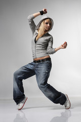 young and stylish dancer posing on grey