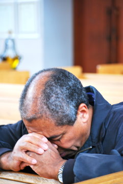 African american man praying in church.