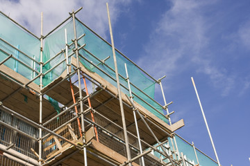 tall building scaffolding against a blue sky