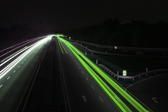 road with car traffic at night and blurry lights showing speed
