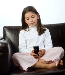 young girl and cell phone on a sofa