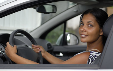 Jeune femme au volant d'une voiture.