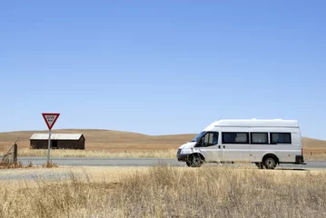 Tuinposter Camper van on its way in the desert in Australia © robepco